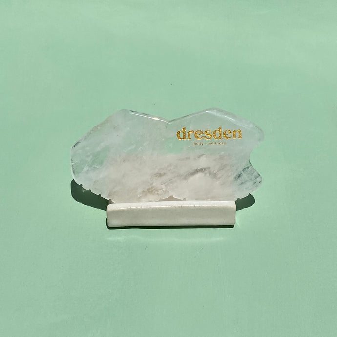 Dresden Body Wellness from Santa Barbara california clear quartz gua sha stone tool in a ceramic gua sha stand