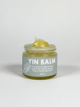 Load image into Gallery viewer, Glass jar of Yin Balm with the balm coming out the top of the jar. Yin Balm is a botanical balm formulated for vulvar comfort and moisture support. Made with herb-infused oils, cocoa butter, mango butter, evening primrose oil, and beeswax for dry, sensitive intimate skin.