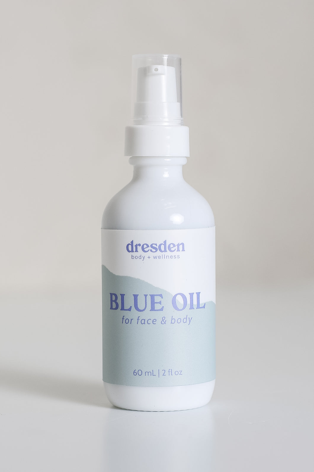 Dresden Holden Acupuncturist in santa barbara california 2 ounce bottle of organic facial oil using frankincense and blue tansy essential oil in a white glass bottle with a blue label and blue writing in an elegant style. 