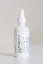 Load image into Gallery viewer, Dresden Holden Body and Wellness acupuncturist based in Santa Barbara california made this organic body oil with the scents of cardamom and cedar, fast absorbing and dry oil feel, a 2 ounce white glass bottle with a blue and white label in blue writing. 
