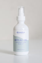 Load image into Gallery viewer, Dresden Holden Body and Wellness acupuncturist based in Santa Barbara california made this organic body oil with the scents of cardamom, fast absorbing and dry oil feel, a 2 ounce white glass bottle with a blue and white label in blue writing. 
