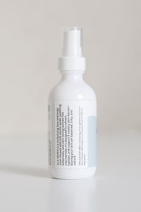 Dresden Holden Acupuncturist in Santa Barbara Ca made Silk water a hydrating toner with organic hydrosols, niacinamide, glycerin, silk amino acids, and is pH balanced to hydrate and heal the skin barrier, in a 2 ounce white glass bottle with a label written in blue font