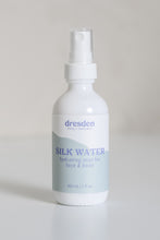 Load image into Gallery viewer, Dresden Holden Acupuncturist in Santa Barbara Ca made Silk water a hydrating toner with organic hydrosols, niacinamide, glycerin, silk amino acids, and is pH balanced to hydrate and heal the skin barrier, in a 2 ounce white glass bottle with a label written in blue font
