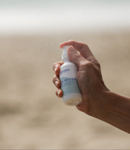 Load image into Gallery viewer, Dresden Holden Santa Barbara Based Acupuncturist and Silk Water spraying into the air to show a fine mist spray for this hydrating pH balanced toner
