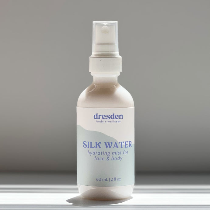 Dresden Body + Wellness Santa Barbara based acupuncturist and skincare. 2 ounce bottle of Silk water peptide serum in a white glass bottle with a fine mist sprayer, contains niacinamide, glycerin
